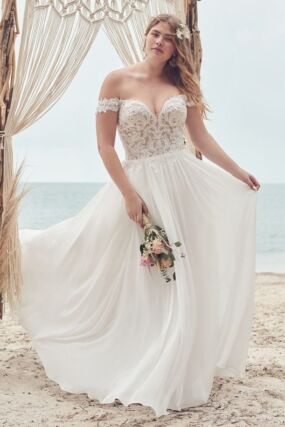 Beautiful bride in flowy a line off the shoulder plus size wedding dress on the beach