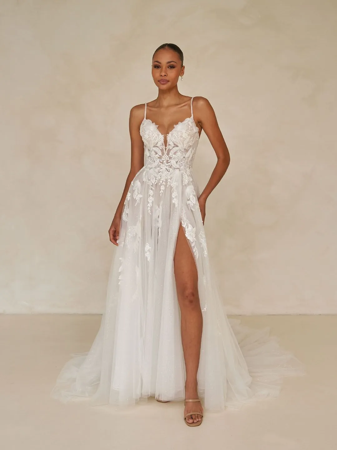 model wearing wedding gown with 3D embroidered lace, is artfully structured with a soft micro-plunge necklin