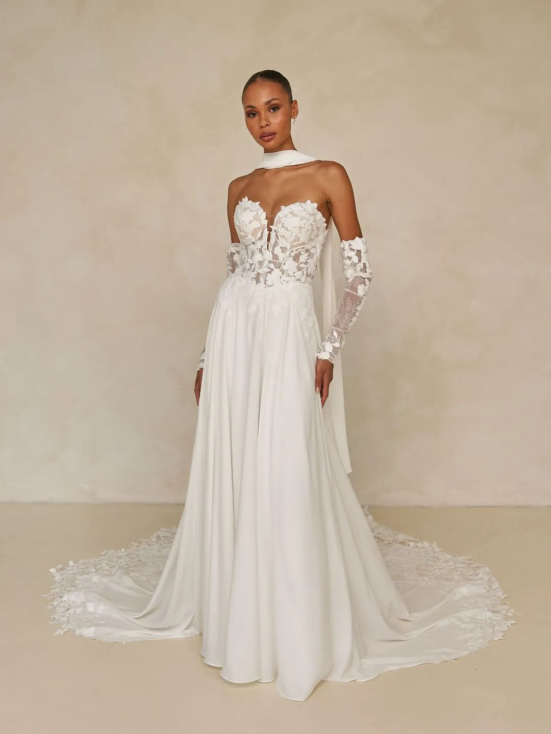 model wearing wedding dress withdelicate lace motifs and refined boning, now enhanced with a Basque waistline